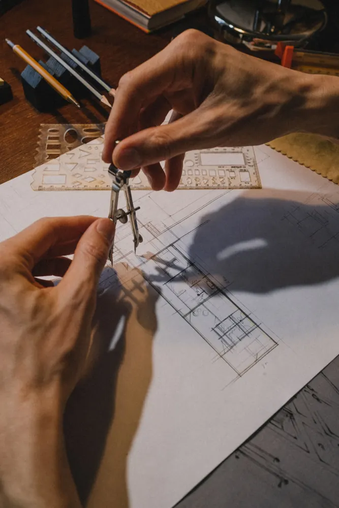 Manos usando un compás sobre un plano