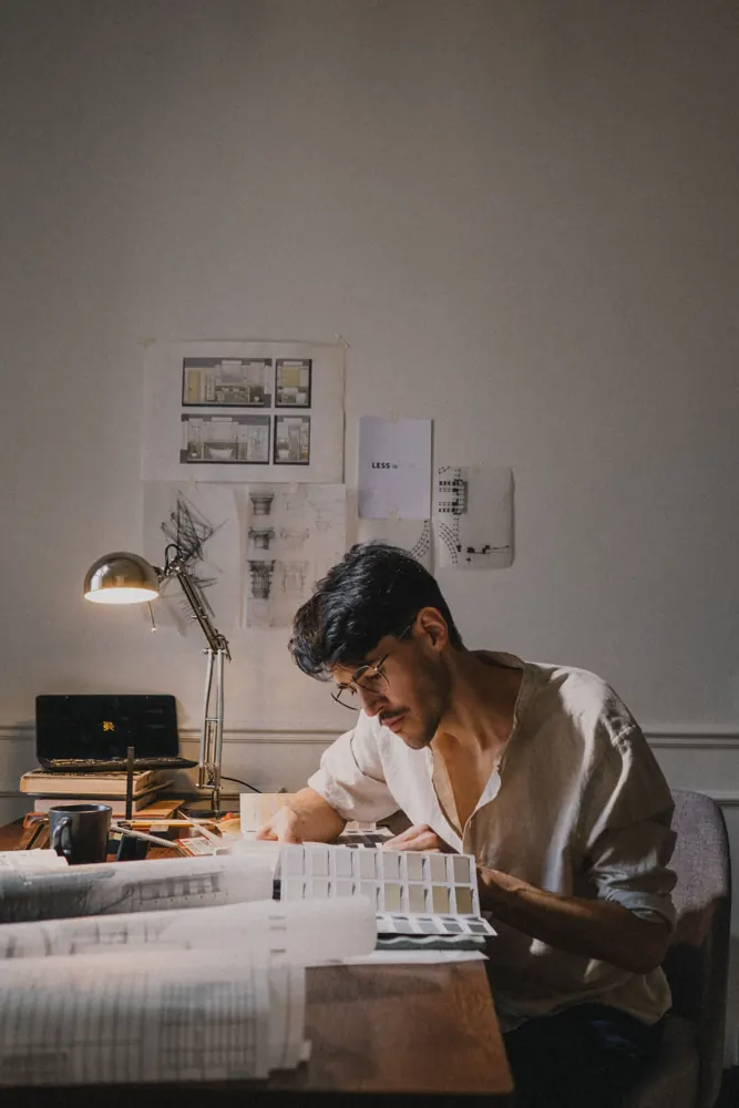Arquitecto trabajando sobre planos en su escritorio